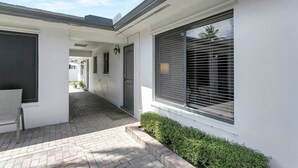 A clean, modern building with a covered walkway, large windows with blinds, and a well-maintained exterior. - Beautiful spacious 2bd, w/d, bbq, yard, pets allowed, free parking  (Delray Beach)