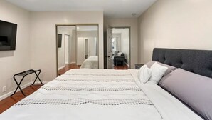 Une chambre à coucher avec un grand lit, une table de chevet, un miroir et une armoire.