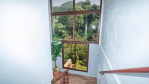A room with a large window offering a view of a lush garden and distant hills. - RIVER VIEW / VILLA FRENTE AL RIO / PEACE BY THE RIVER (Las Guázaras)