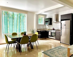 A modern kitchen with a dining area, featuring a stove, microwave, and refrigerator.