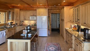 A spacious kitchen with wooden cabinets, a central island, and a microwave.
