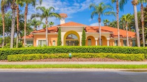 A hotel with a red-tiled roof, arched entrance, and palm trees. - Spacious Resort Villa w/ Private Pool, Game Room & Disney Nearby! (Davenport)