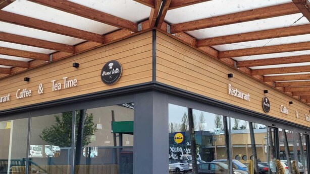 Ein Restaurant mit einer Holzhaut und großen Glasfenstern.