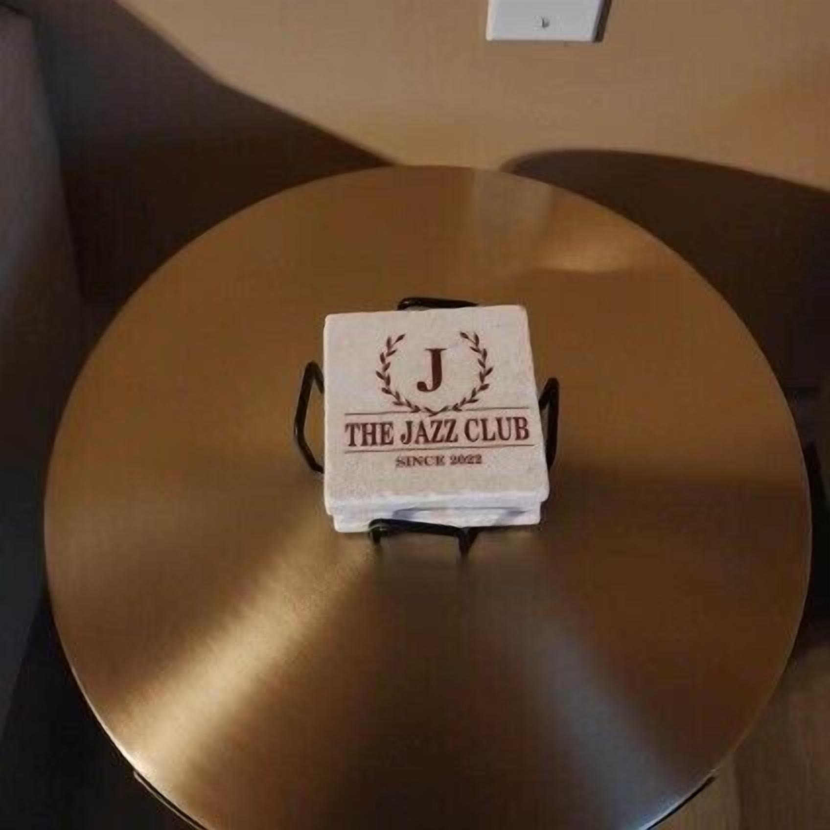 A round table with a white cloth that reads "THE JAZZ CLUB SINCE 2022".