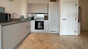 A modern kitchen with white cabinetry, a microwave, a sink, and a dishwasher. - 1 Bed w/ Parking| Ideal for work stays By Tempstay (Slough)
