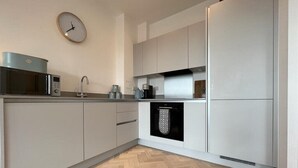 A modern kitchen with a microwave, kettle, and dishwasher. - 1 Bed w/ Parking| Ideal for work stays By Tempstay (Slough)
