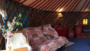Ein gemütliches Interieur mit einem gemusterten Sofa, einem Holztisch und einer dekorativen Vase mit Blumen.