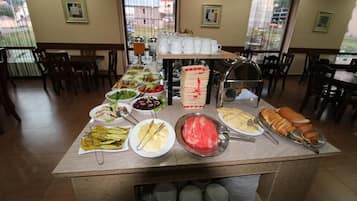 A buffet setup with various food items and utensils.