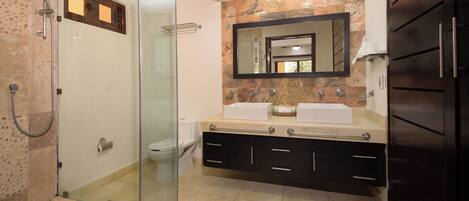 A modern bathroom with a glass-enclosed shower, a double sink vanity, and a large mirror.