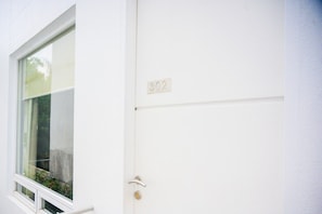 A white door with a number plate '302' and a window with a white frame.