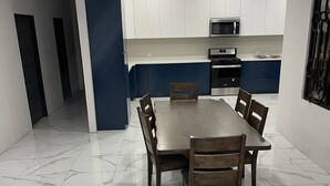 Una cocina moderna con armarios blancos, un microondas y una estufa.