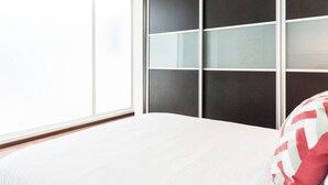 A bedroom with a bed, a window, and a wall with a geometric pattern. - Condesa Residence Amsterdam  201- Close from parks (Ciudad de México)