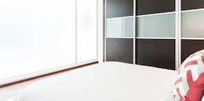 Una camera da letto con un letto, una finestra e una parete con motivo geometrico.