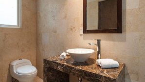 A bathroom with a marble sink, a mirror, and a toilet. - Condesa Residence Amsterdam  201- Close from parks (Ciudad de México)