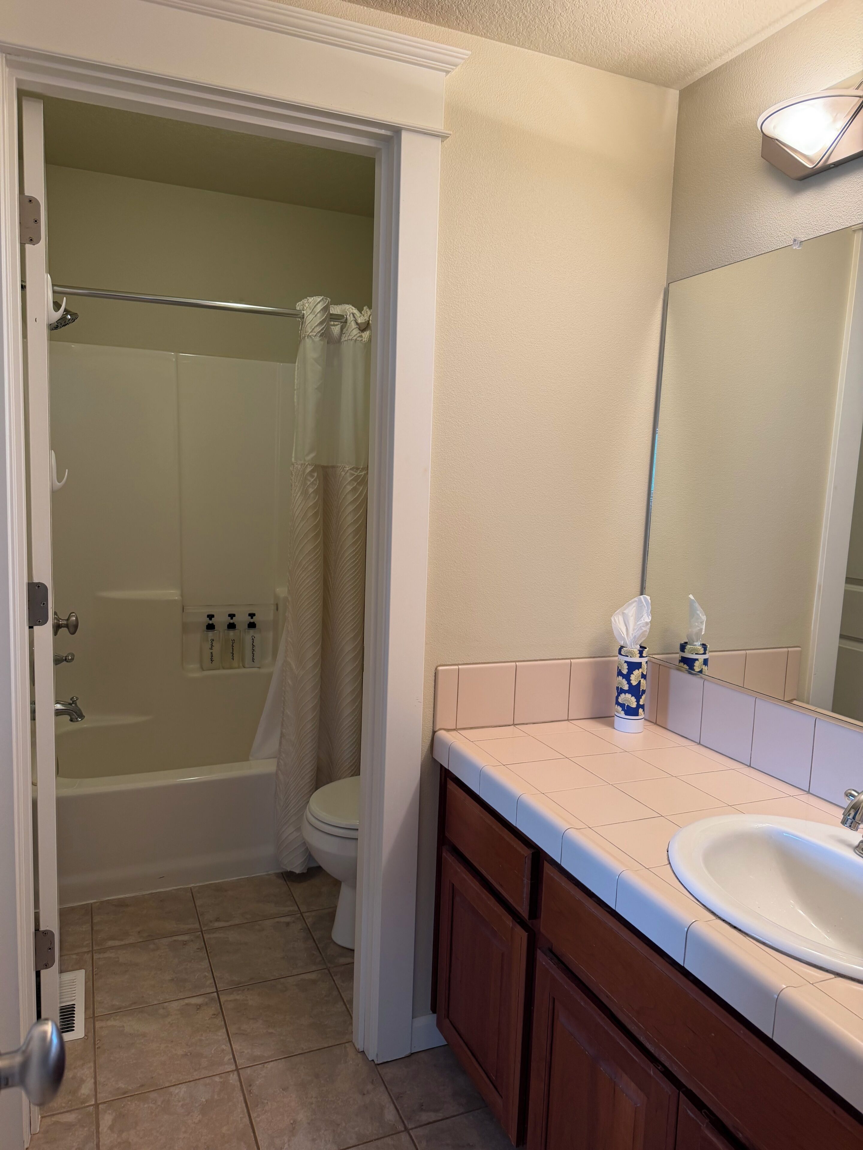 A bathroom with a bathtub, toilet, sink, and a mirror.
