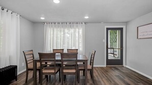 A dining area with a table and chairs, a window with curtains, and a door leading outside. - Entire 2nd and 3rd level of Spacious Historic Home (Spokane)