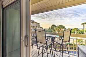 Enjoy the ocean view from this balcony with two comfortable chairs and a small table.