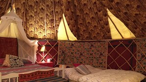 Et hyggeligt og velindrettet værelse med seng, sengebord, lampe og dekorative puder.