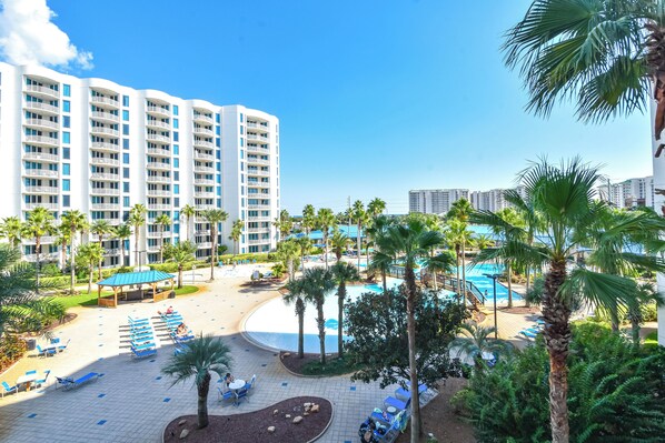 A resort with a pool area, palm trees, and a large building with multiple balconies. - Beachy Condo w/ Lagoon-Style Pool Views at The Palms of Destin! πβπ΄ (Destin)