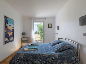Une chambre à coucher avec un lit, une affiche, une porte et une vue sur l’extérieur.
