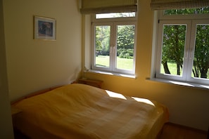 Une chambre à coucher avec un lit, une fenêtre et une petite table de chevet.
