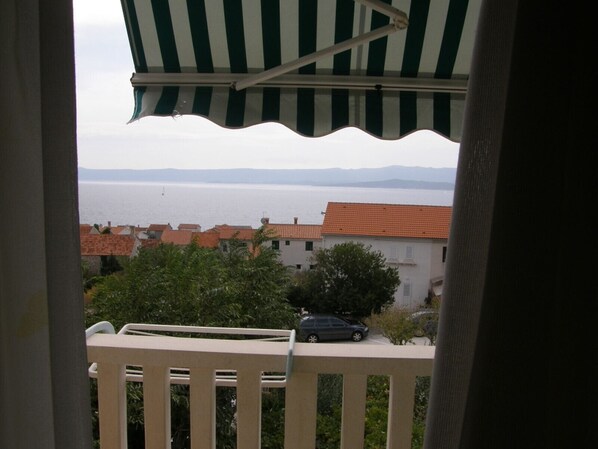 A balcony with a view of a coastal town and the sea.