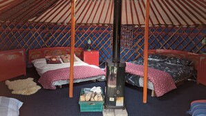 A traditional yurt with two beds, a central heating pole, and a storage chest. - Eco Glamping immersed in nature, ideal for family holidays andromantic getaways! (Whitegate)