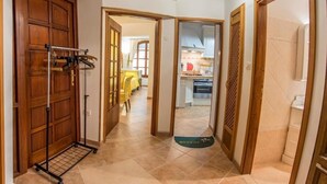 A hallway with a wooden door, a rack with hanging items, and a welcome mat leading to a kitchen area. - Apartment in Banjole with Air condition, WIFI, Washing machine (3360-2) (Banjole)