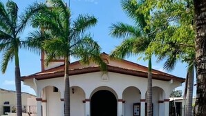 A church with a cross on top, surrounded by palm trees.
