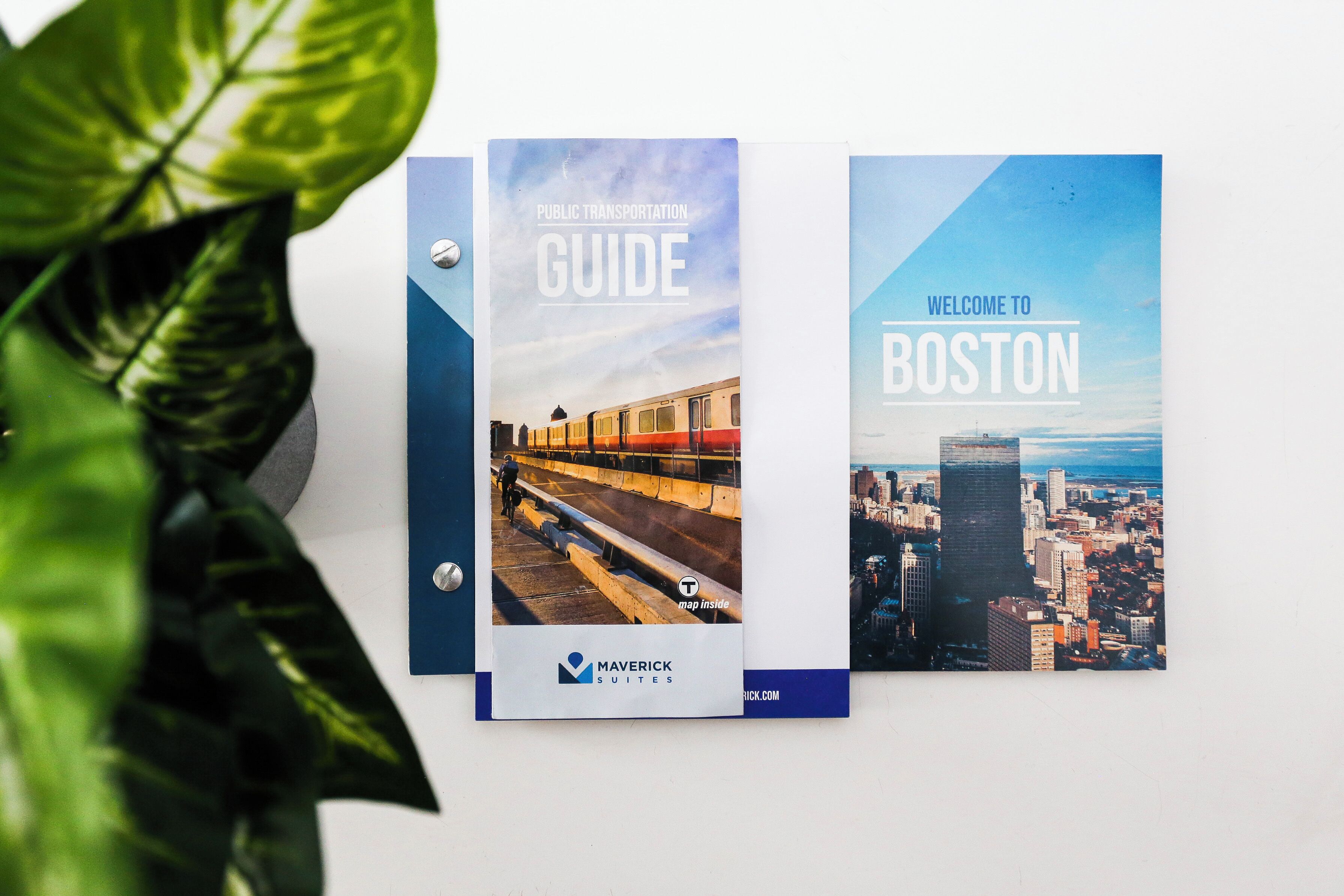 Twee reisgidsen, getiteld 'Public Transportation Guide' en 'Welcome to Boston', met een stadsbeeld en een trein.