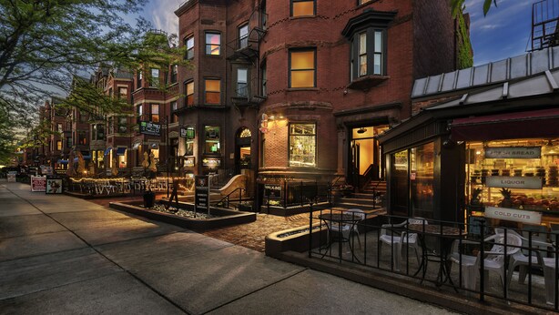 A row of brick buildings with storefronts, including a bakery and a liquor store.