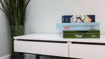 A white desk with three board games stacked on top.