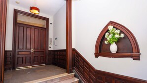 A wooden staircase leading to a door with a light fixture above it.