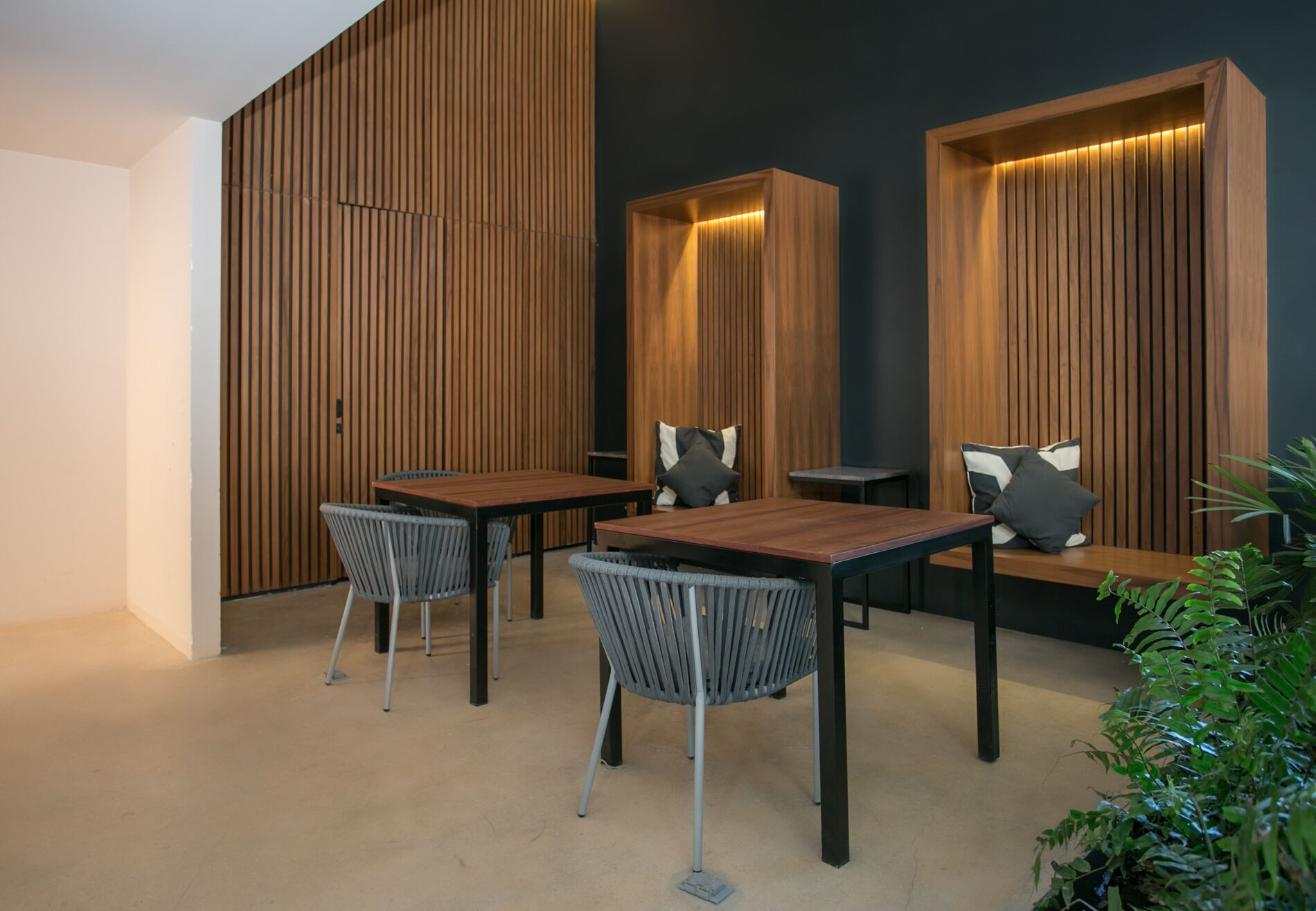 A modern interior with a wooden panel wall, a wooden table, and two chairs.