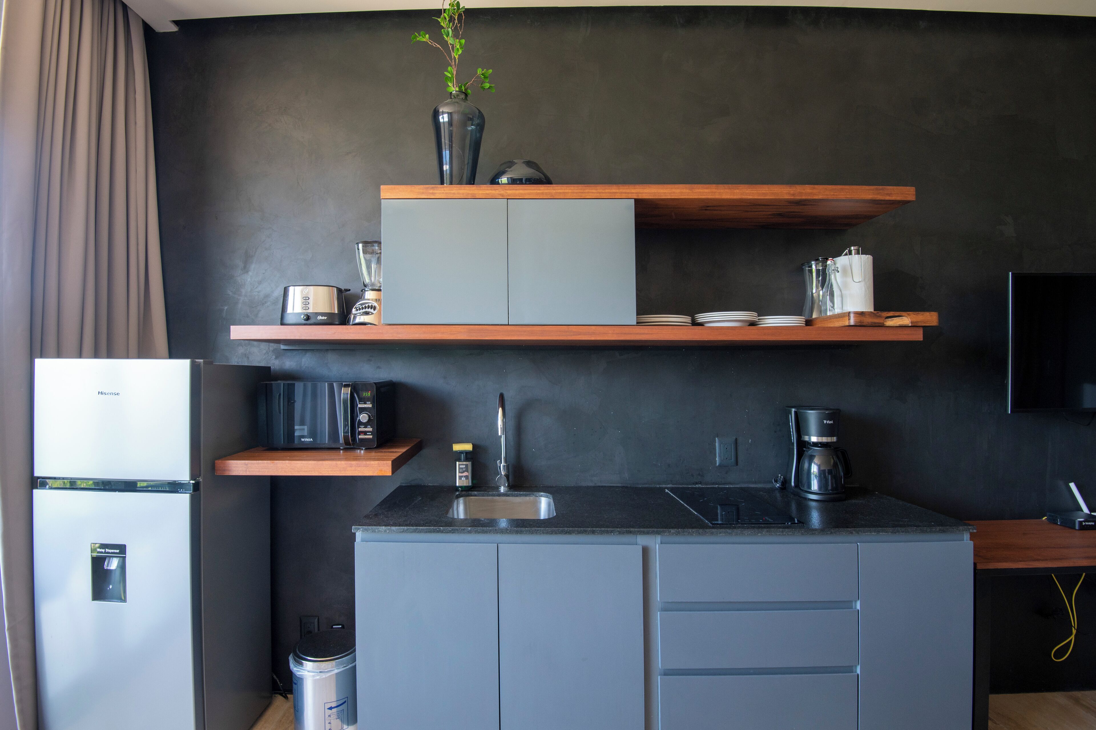 A compact kitchen with a refrigerator, microwave, and coffee maker.