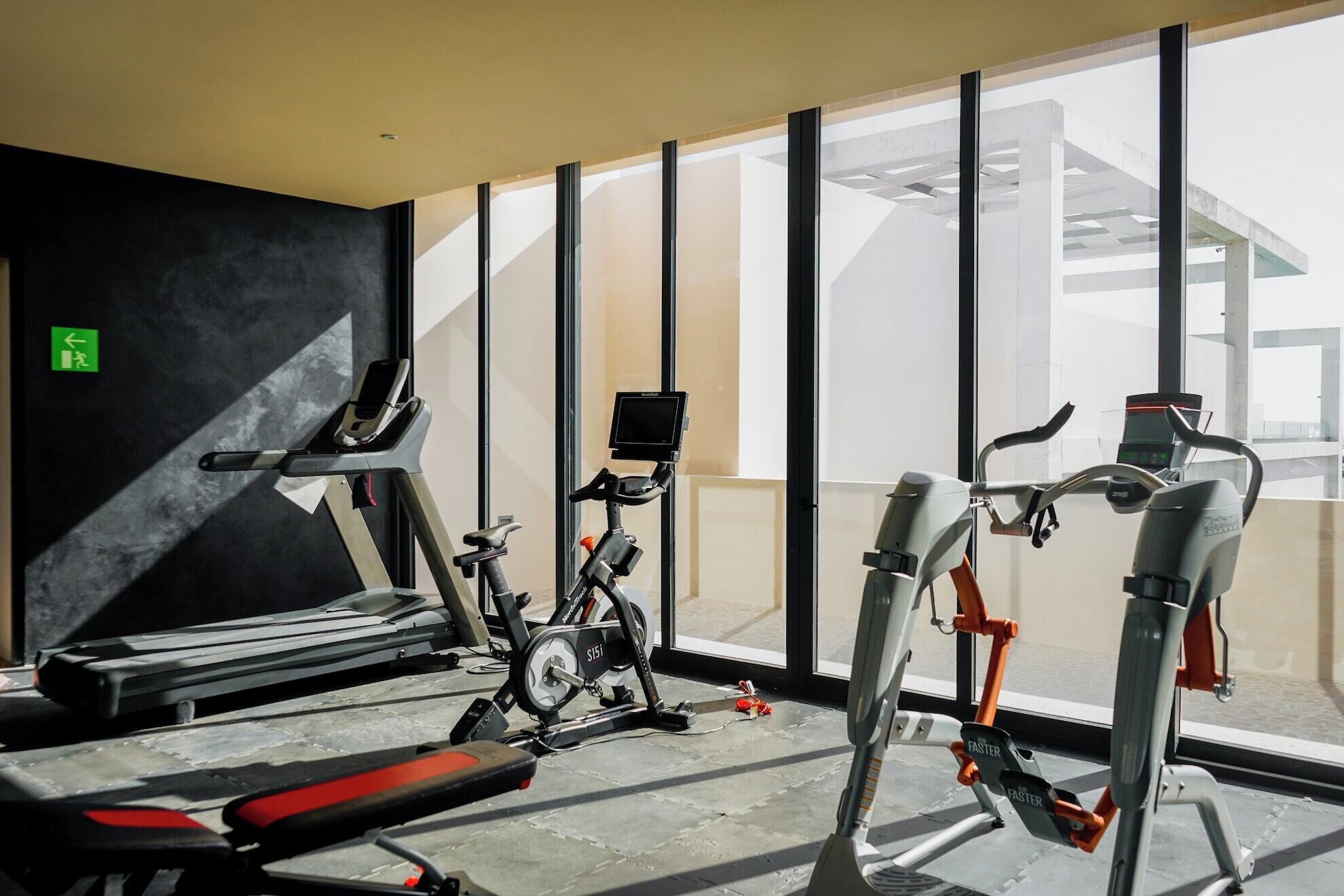 A gym with treadmills, stationary bikes, and weight machines.
