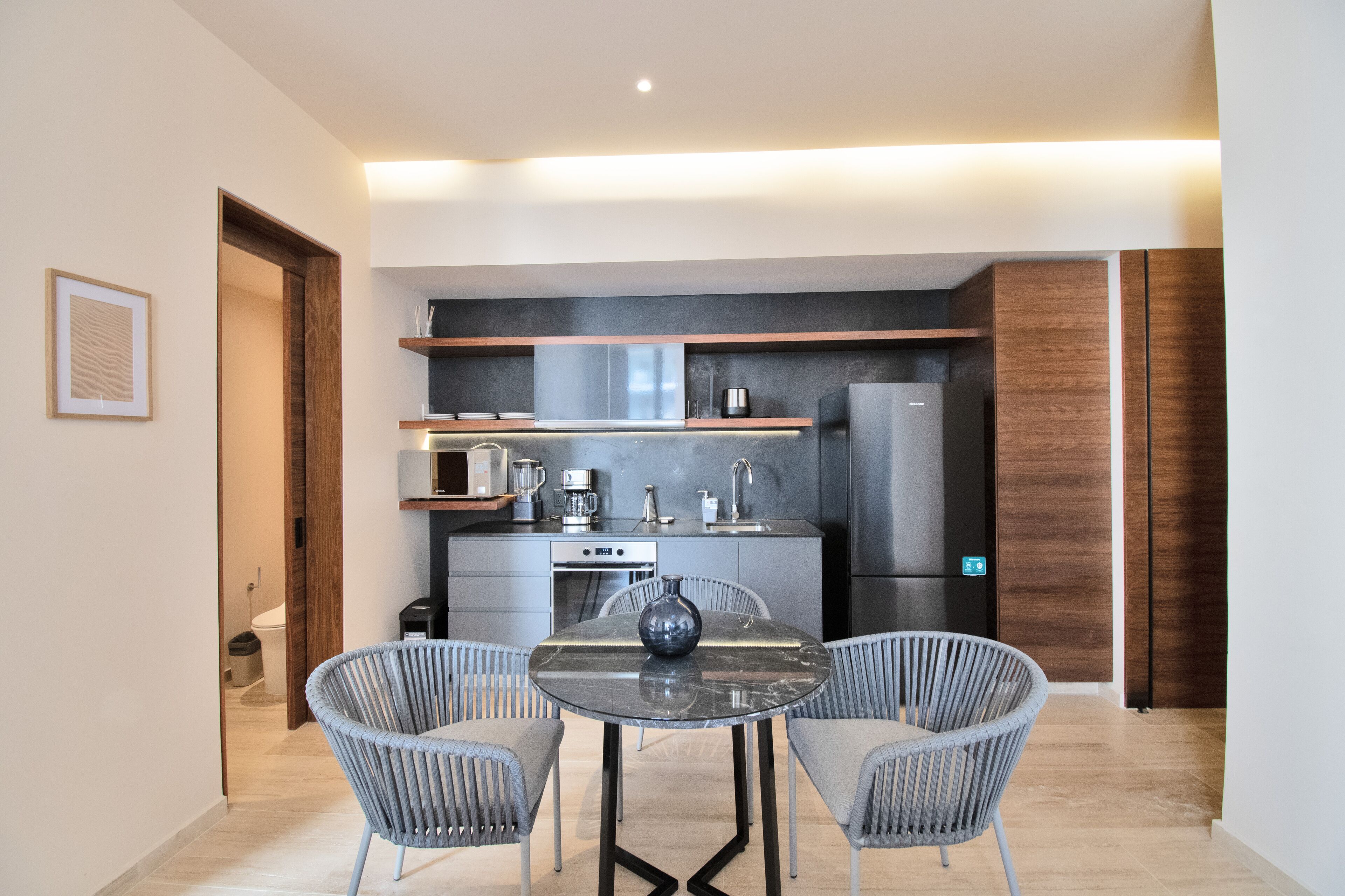 Une cuisine moderne avec un coin repas, comprenant une table ronde, deux chaises et un vase.