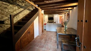 A rustic interior with a stone staircase, a wooden ceiling, and a tiled floor. - Rural house, ideal for families in the middle of nature. (Júzcar)