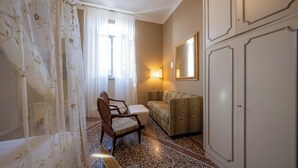 Quarto com sofá, poltrona, luminária e armário.