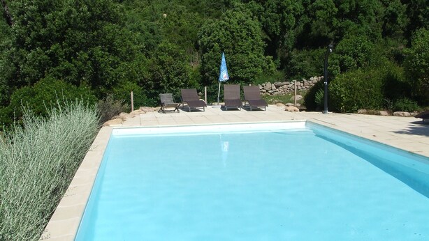 A swimming pool with lounge chairs and a blue umbrella. - Semi-detached mini villa for 6 people in a small, quiet, natural family residence (San-Gavino di Carbini)