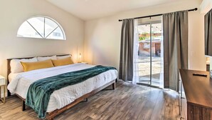 Un dormitorio con cama, escritorio, ventana y vistas al exterior.