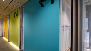 A hallway with teal walls, a large black directional sign, and a window with sheer curtains. - dpaso hostel (Chantada)