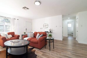 Un salon moderne avec deux canapés, une table basse et une petite table d’appoint.