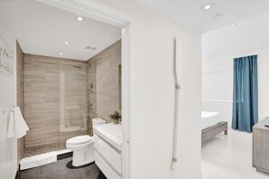 Une salle de bain moderne équipée d’une douche, de toilettes et d’un lavabo.
