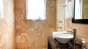 A bathroom with a glass-enclosed shower, a white sink, and a marble countertop. - Condesa Residence Amsterdam F (Ciudad de México)