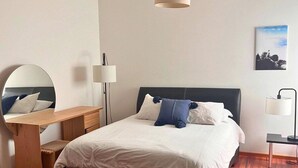 A bedroom with a bed, bedside table, lamp, and a mirror. - Condesa Residence Amsterdam F (Ciudad de México)