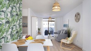 Un espace de vie moderne comprenant un coin repas, un canapé et un fauteuil.