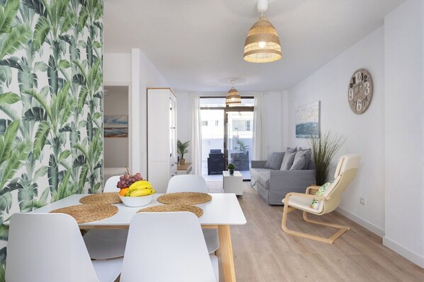 A modern living space with a dining area, a sofa, and a chair. - Home2Book Dream Apartment Altemar Las Américas (Playa de la Américas)