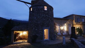 A stone tower with a small window, a door, and a light source inside. - Location, unique charm, beach, pool, forest, comfort, 360º views (Malveira da Serra)