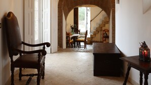 A spacious room with a high arched brick ceiling, a wooden chair, a table, and a chandelier. - Location, unique charm, beach, pool, forest, comfort, 360º views (Malveira da Serra)